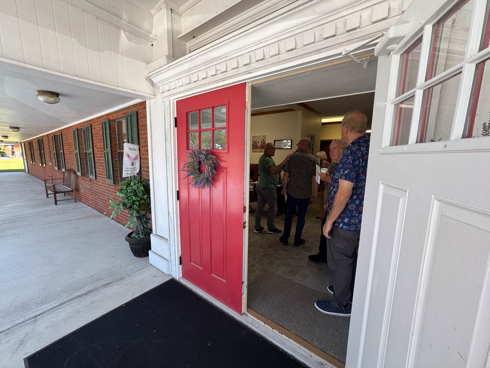 open door showing people visiting in the church lobby.